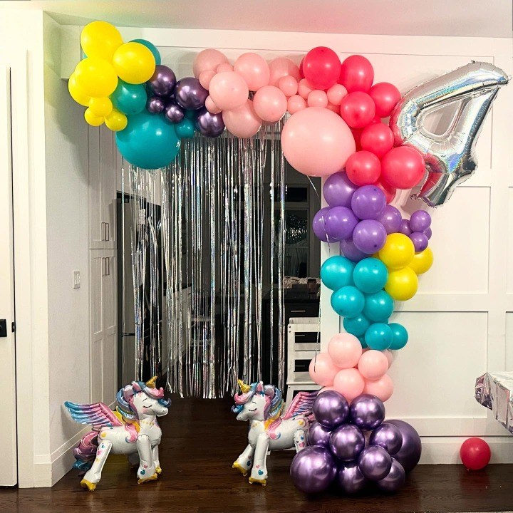 Bright balloon arch with a fringe backdrop